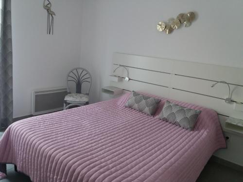 a bedroom with a pink bed with a pink comforter at Park Horizon in Sainte-Maxime