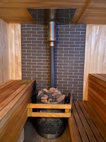 a fire pit in a sauna with a brick wall at Vilni Vitry in Osmoloda