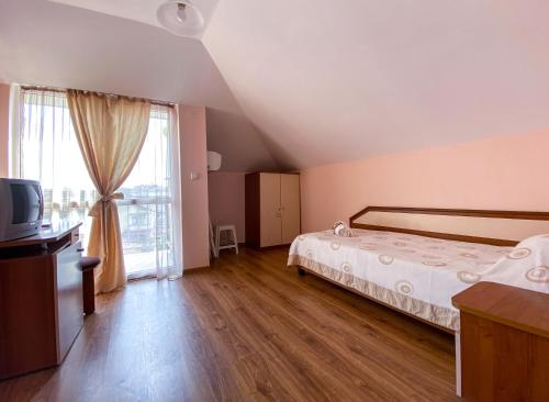 ein Schlafzimmer mit einem Bett und einem großen Fenster in der Unterkunft Vanessa Family Hotel in Rawda