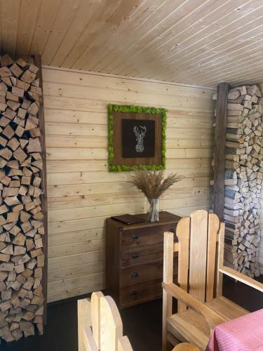 a room with a wooden wall with a table and chairs at Vilni Vitry in Osmoloda