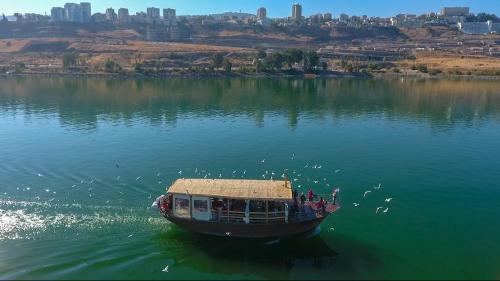 a boat floating on a large body of water at Selfie's Boutique Hotel in Tiberias