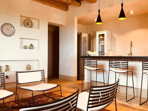 a kitchen with black and white chairs and a counter at Case Graffeo in Menfi