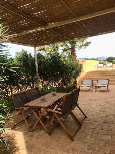 a wooden picnic table and chairs under a roof at Case Graffeo in Menfi