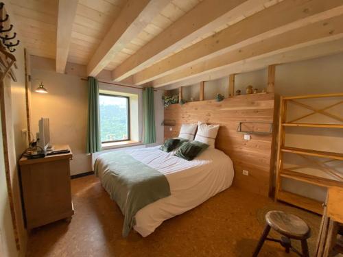 a bedroom with a large bed with a wooden wall at La Ferme sous les Hiez in Cornimont