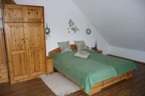 um quarto com uma cama e um armário de madeira em Ferienwohnung Regina em Staufen