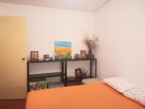a bedroom with a bed with an orange bedspread at Refúgio do Douro Guest House in Bemposta