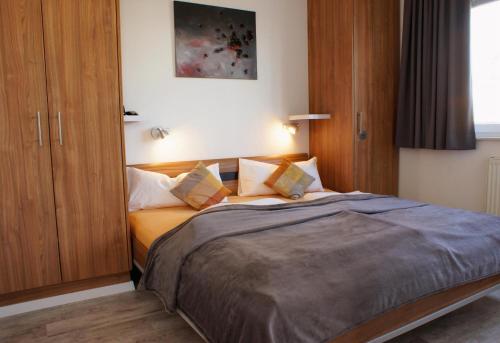 a bedroom with a large bed with wooden cabinets at Strandpark Seeanemone im Haus Windrose 11 in Großenbrode