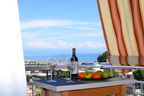 un tavolo con una bottiglia di vino e una ciotola di frutta di Hotel Perdja a Velipojë