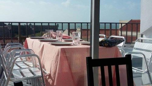 a table with glasses and chairs on a balcony at 66 Peniche in Peniche