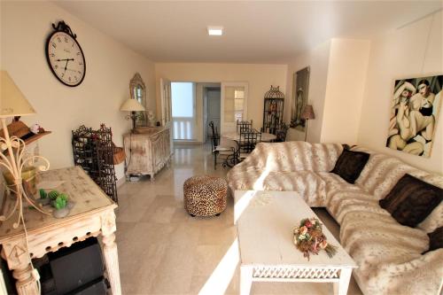 un salon avec un canapé et une horloge au mur dans l'établissement Apartment 2 bedrooms2 bathroomsterrace equipped in Palm beach area, à Cannes