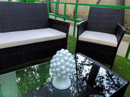 two chairs and a glass table with a vase on it at Villa Mallandrino in Mondello