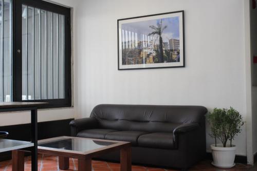 a living room with a leather couch and a table at Hamra Urban Gardens in Beirut