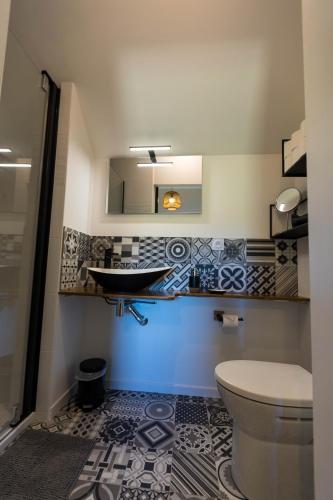une salle de bain avec un lavabo et des toilettes dans l'établissement La maison de Jean, à Milizac