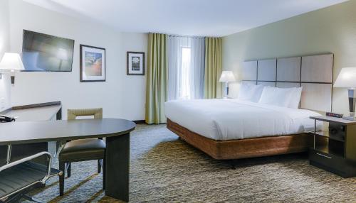 a hotel room with a bed and a desk at Candlewood Suites Lakeville I-35 by IHG in Lakeville