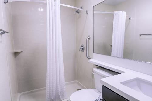 a bathroom with a shower and a toilet and a sink at Candlewood Suites Lakeville I-35, an IHG Hotel in Lakeville