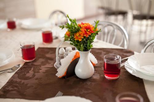 ein Tisch mit einer weißen Vase mit Blumen darin in der Unterkunft Gorczański Kącik in Ochotnica Dolna