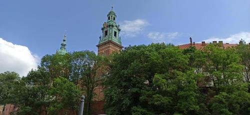 un bâtiment avec une tour d'horloge en haut dans l'établissement Bailey Apartment, à Cracovie