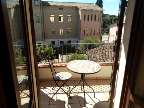 a balcony with a table and chairs and a view of a building at Camere Paolo in Assisi