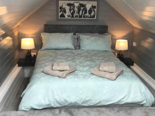 a bedroom with a bed with two towels on it at Wagtail Cottage in Tarporley
