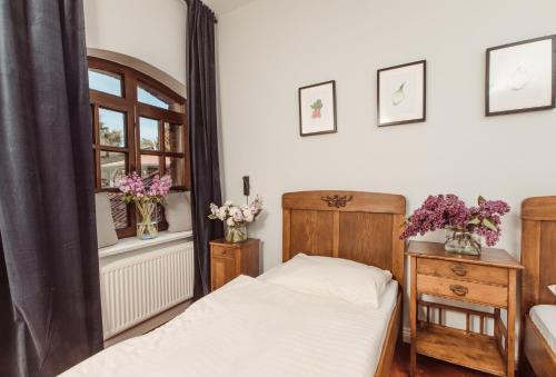 a bedroom with a bed and a window with flowers on the wall at Tabun in Gdańsk