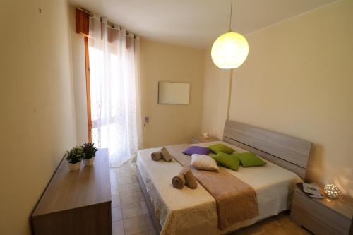 una camera da letto con un letto con cuscini verdi e viola di Casa vacanze Nicole in Salento 5 posti a Otranto