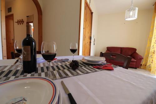a bottle of wine and two glasses on a table at Casa vacanze Nicole in Salento 5 posti in Otranto