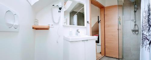 a white bathroom with a sink and a shower at Apotek Guesthouse in Höfn