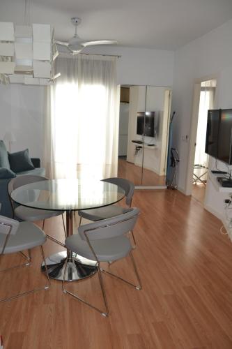 sala de estar con mesa de cristal y sillas en Apartamento Barrio Picasso en Málaga