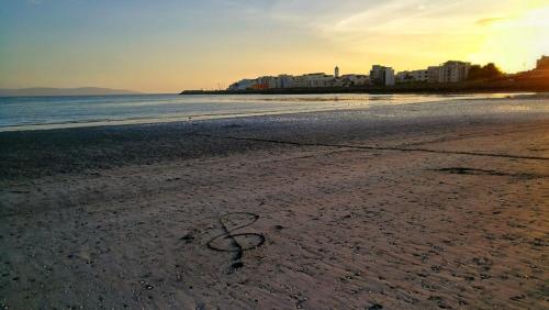 a heart drawn in the sand on a beach at The Nest Boutique Hostel in Galway