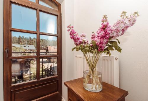 a vase of flowers on a table next to a window at Tabun in Gdańsk