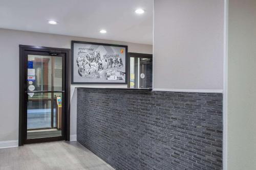 a room with a brick wall and a glass door at Super 8 by Wyndham Florence in Florence