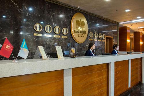 Dos mujeres de pie en un mostrador en un restaurante en King Hotel Astana en Astaná