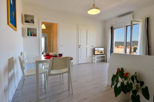 a dining room and living room with a table and chairs at Lyceum Flat in Olbia