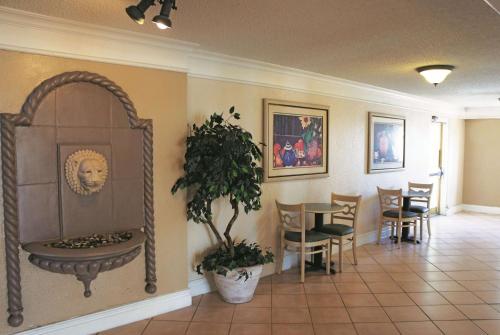 a dining room with a table and a potted plant at La Quinta Inn by Wyndham Clute Lake Jackson in Clute