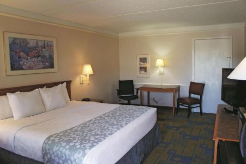 a hotel room with a bed and a desk at La Quinta Inn by Wyndham Clute Lake Jackson in Clute