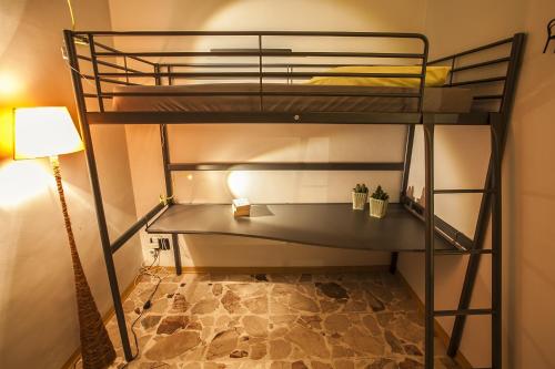 a room with two bunk beds and a lamp at Ostello degli Elefanti in Catania