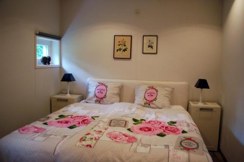 a bedroom with a bed with pink roses on it at De Riekhoff in Een-West