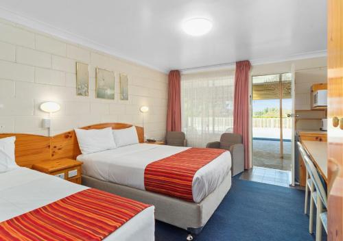 a hotel room with two beds and a balcony at Econo Lodge Alabaster in Cowra