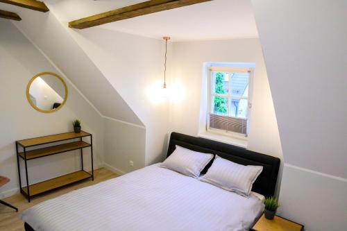 a bedroom with a bed with a mirror and a window at Castella Apartments in Pärnu