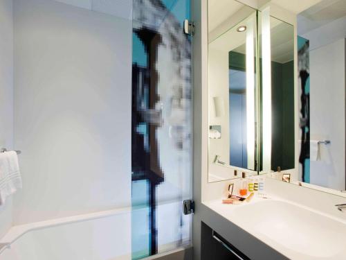 a bathroom with a sink and a mirror at Mercure Pont d’Avignon Centre in Avignon