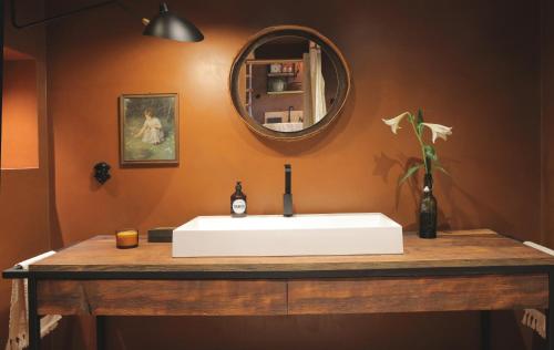 ein Badezimmer mit einem weißen Waschbecken und einem Spiegel in der Unterkunft ANNAS STUBE - Boutique Design Bauernhof in Waldkirch