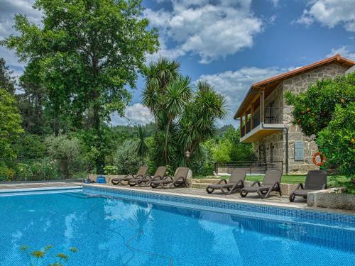 a swimming pool with lounge chairs and a house at Casa do Rio in Mondim de Basto