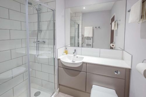 ein Bad mit einem WC, einem Waschbecken und einer Dusche in der Unterkunft Trouville Hotel in Sandown