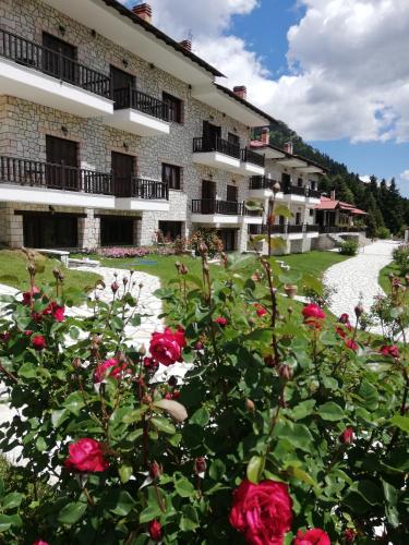 a building with red roses in front of it at Ξενοδοχείο ΜΑΓΚΙΩΣΗ in Neraïdochóri
