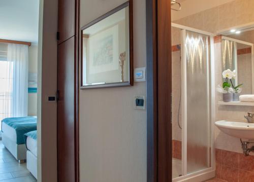een badkamer met een toilet, een wastafel en een spiegel bij Belvedere Resort Hotels in Izola