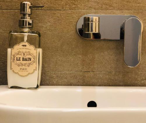 a bottle of soap sitting on top of a sink at Belsiana Luxury Apartment in Rome
