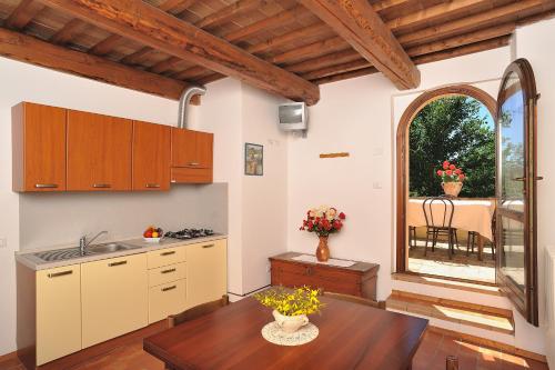 a kitchen with wooden cabinets and a table with flowers on it at Country House Ca' Vernaccia in Urbino
