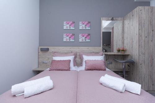 a bedroom with a large bed with pink sheets and pillows at Golden Seaside 1 in Nea Roda