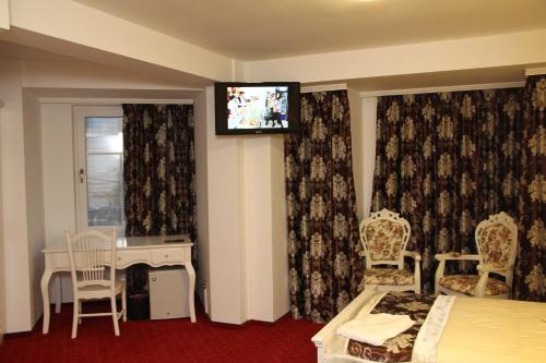 Una televisión o centro de entretenimiento en Hotel Helin Central