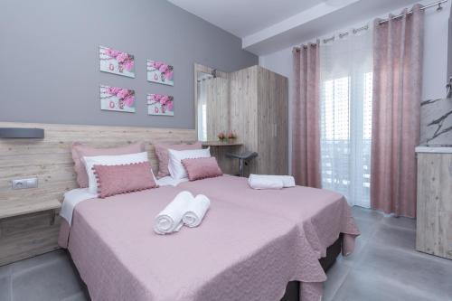 a bedroom with a large bed with two towels on it at Golden Seaside 1 in Nea Roda